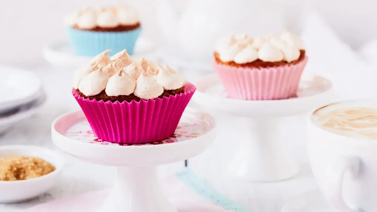Rhabarber Muffins mit Baiser: Süße Leckereien in bunten Förmchen, bereit für den Genuss mit einer Tasse Kaffee.