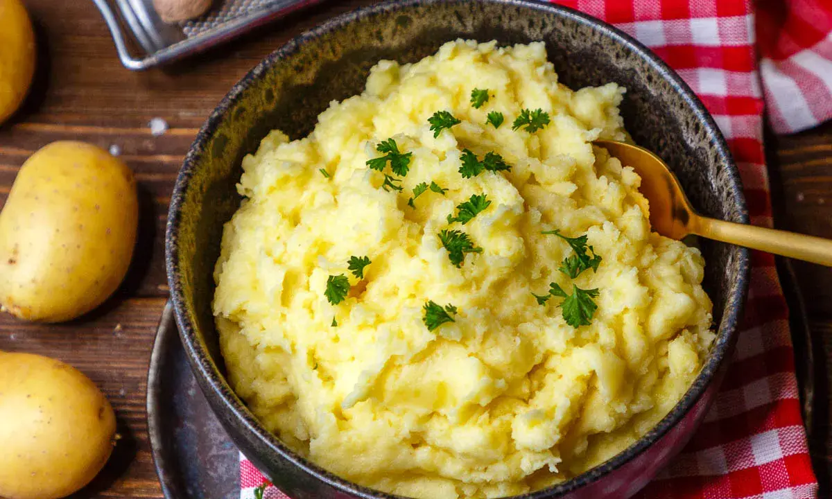 Cremiger Kartoffelbrei, garniert mit Petersilie. Ein einfaches Kartoffelbrei Rezept für ein köstliches Gericht.