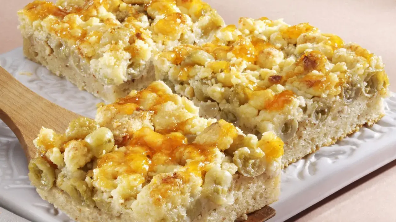 Saftiger Stachelbeerkuchen mit Streuseln, goldbraun gebacken und mit einem Hauch von Honigglanz überzogen.