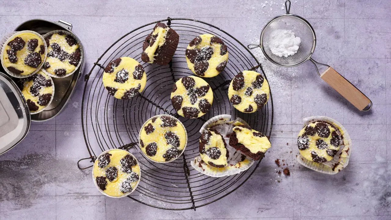 Zupfkuchen Muffins mit Puderzucker bestäubt, auf einem Gitter und in einer Dose.