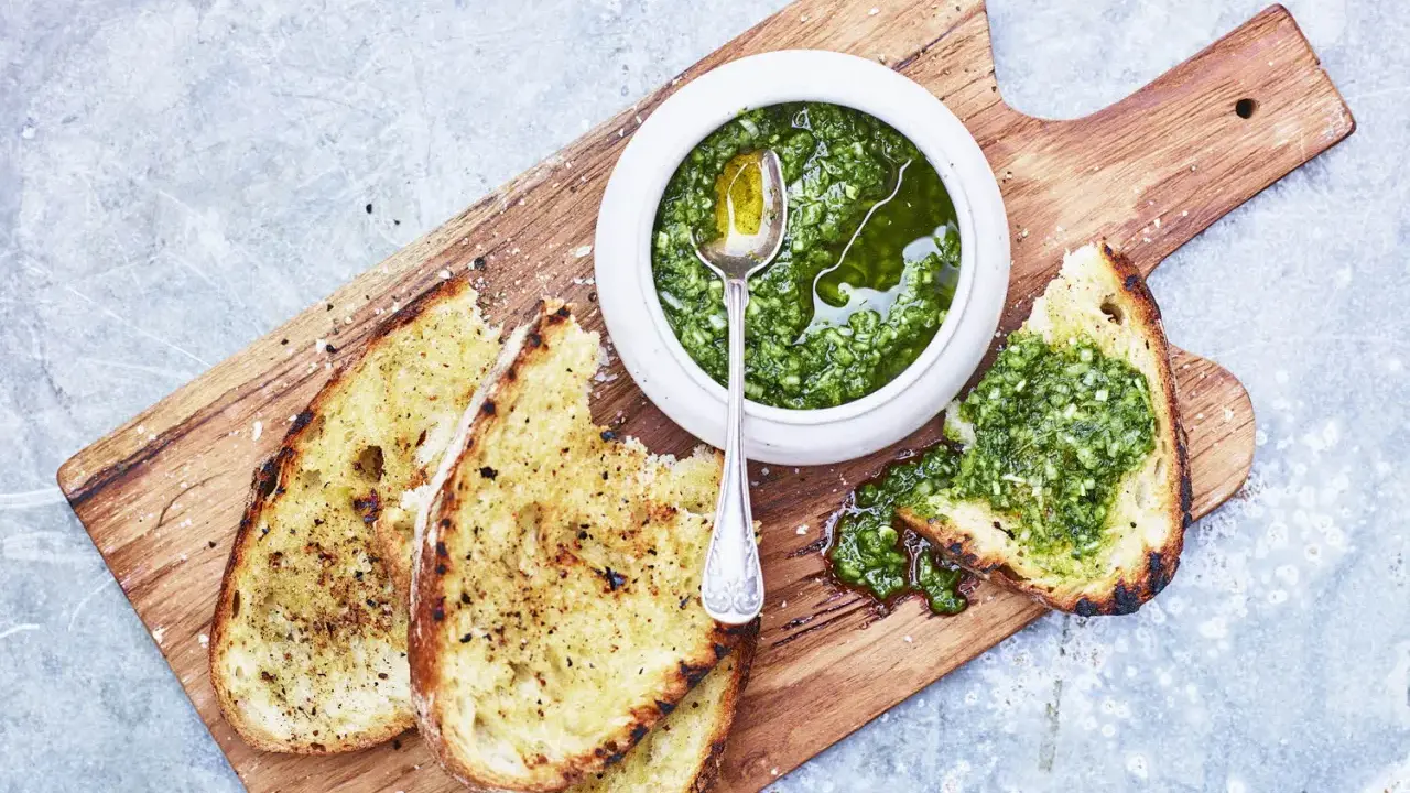 Geröstetes Brot mit frischem Chimichurri-Rezept. Ein Löffel in der Schüssel mit der grünen Sauce.