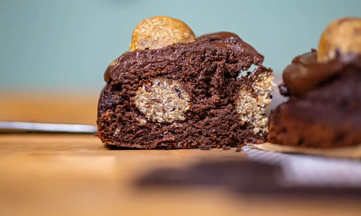 Saftiger Schokoladenkuchen mit versteckten Cookie Dough Kugeln und einem Topping aus Schokoladenglasur und einer weiteren Cookie Dough Kugel.