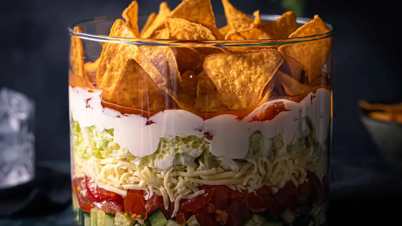 Schichtsalat im Glas: knackiger Salat, Tomaten, Käse, saure Sahne und Tortilla-Chips. Ein leckerer nacho salat.