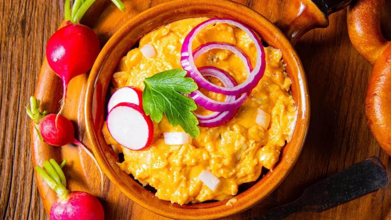 Leckeres Obazda Rezept mit Radieschen und Zwiebelringen garniert, bereit zum Genießen.
