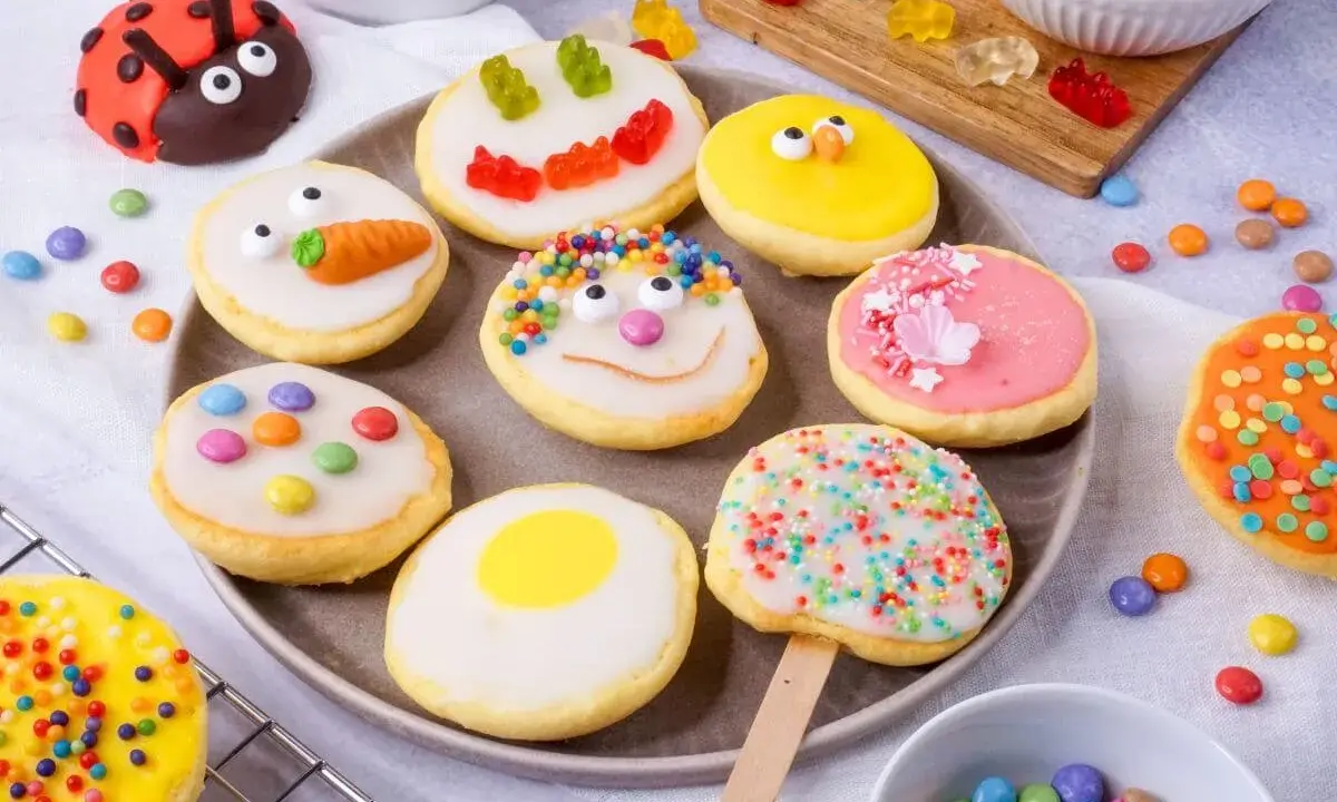 Bunte Kekse mit Zuckerguss, inspiriert von einem amerikanischen Rezept: Marienkäfer, Küken, Karotten und Gesichter.