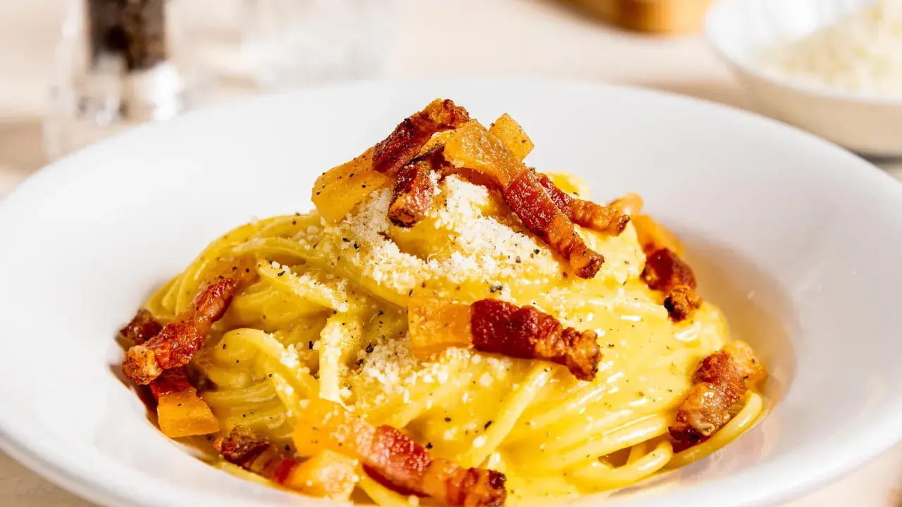 Spaghetti Carbonara mit knuspriger Pancetta, cremigem Ei und Käse bestreut. Ein Klassiker der italienischen Küche.