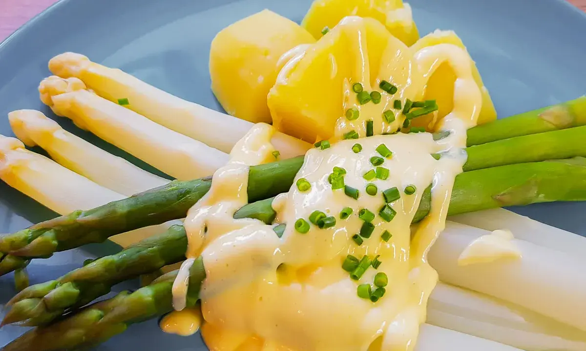 Spargel mit Kartoffeln und cremiger sauce hollandaise, garniert mit Schnittlauch.