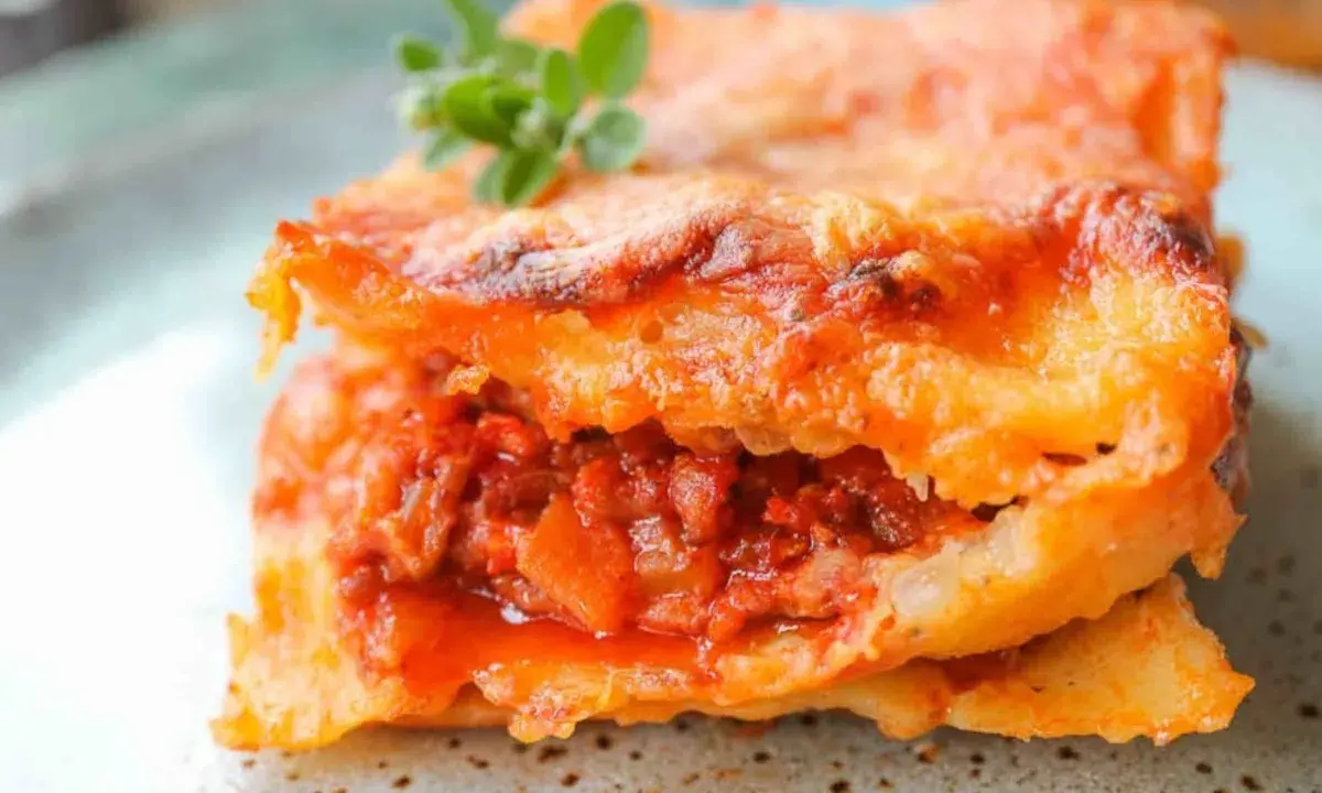 Ein Stück authentische Lasagne Bolognese, perfekt geschichtet und mit Käse überbacken. Ein echtes lasagne rezept original.