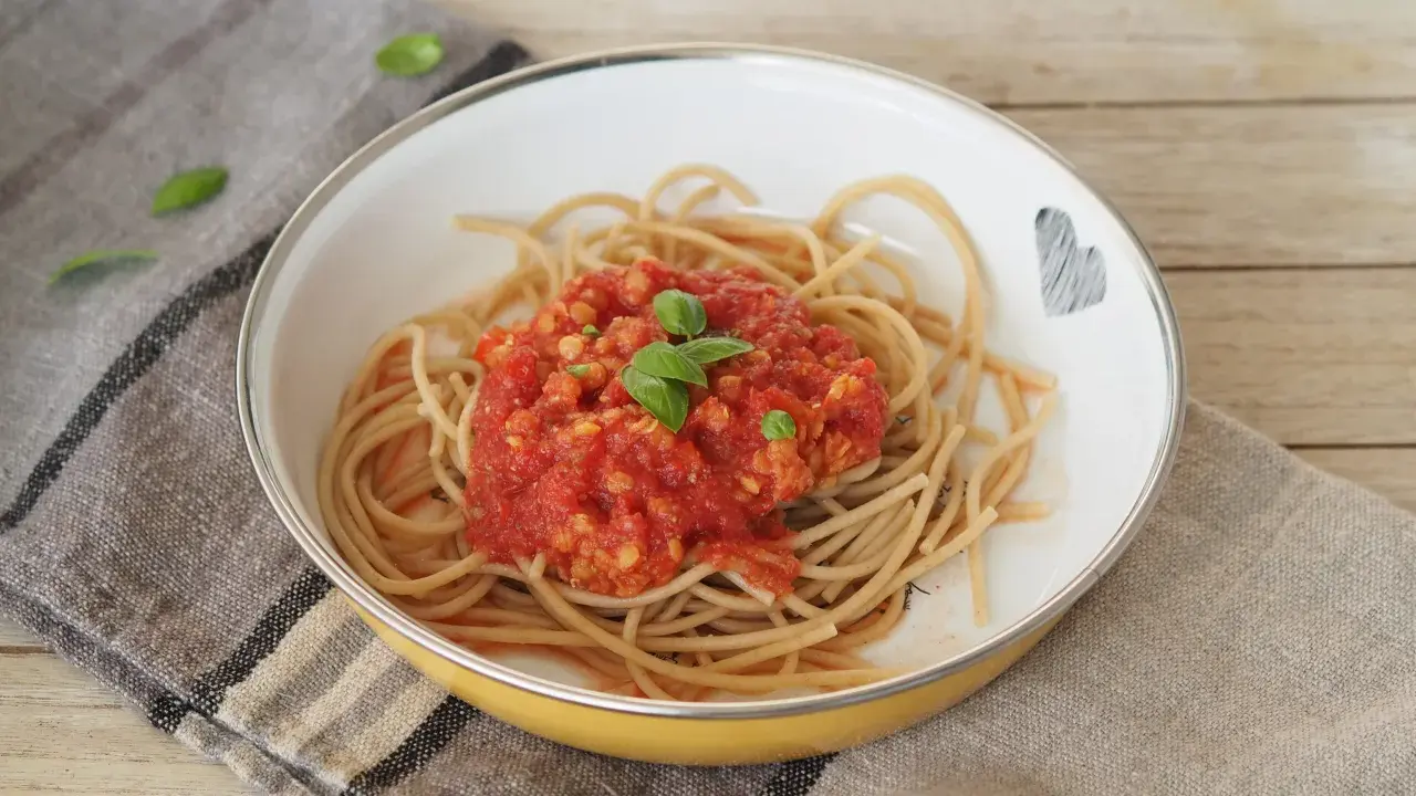 Herzhafte Linsen Bolognese auf Vollkornspaghetti, garniert mit frischem Basilikum. Ein Gericht, das Liebe und Geschmack vereint.