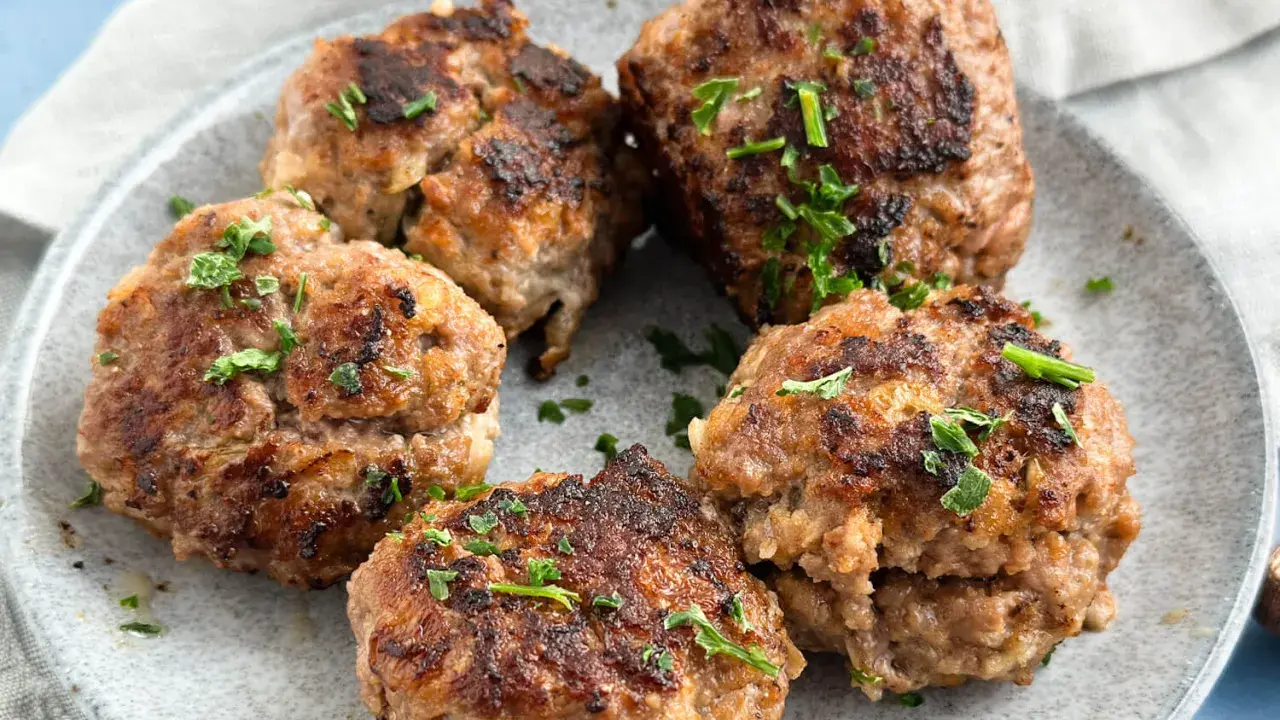 Frikadellen, frisch gebraten und mit Petersilie garniert, bereit für ein leckeres Frikadellen Rezept.