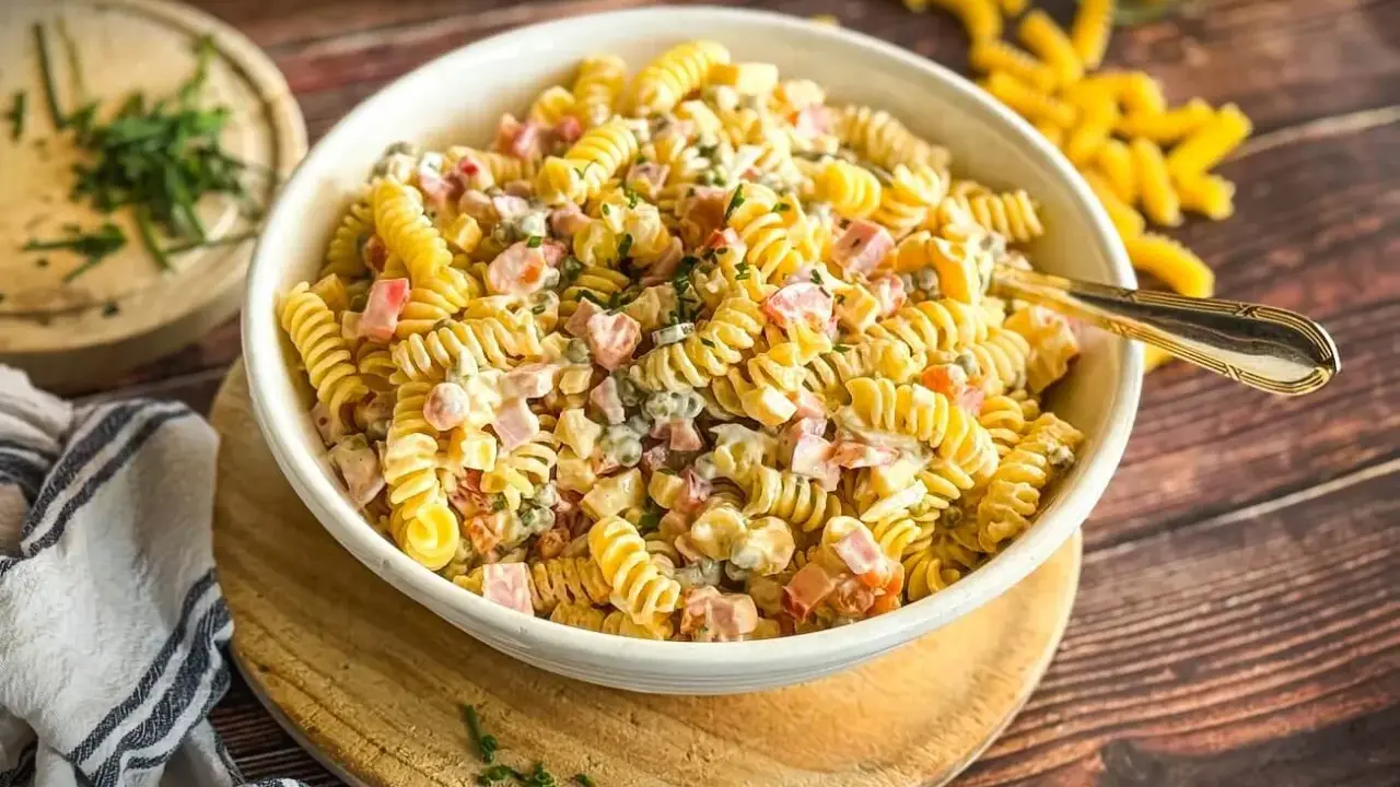 Schüssel mit cremigem Nudelsalat, gefüllt mit Schinken, Erbsen und Kräutern. Der beste Nudelsalat für jede Gelegenheit!