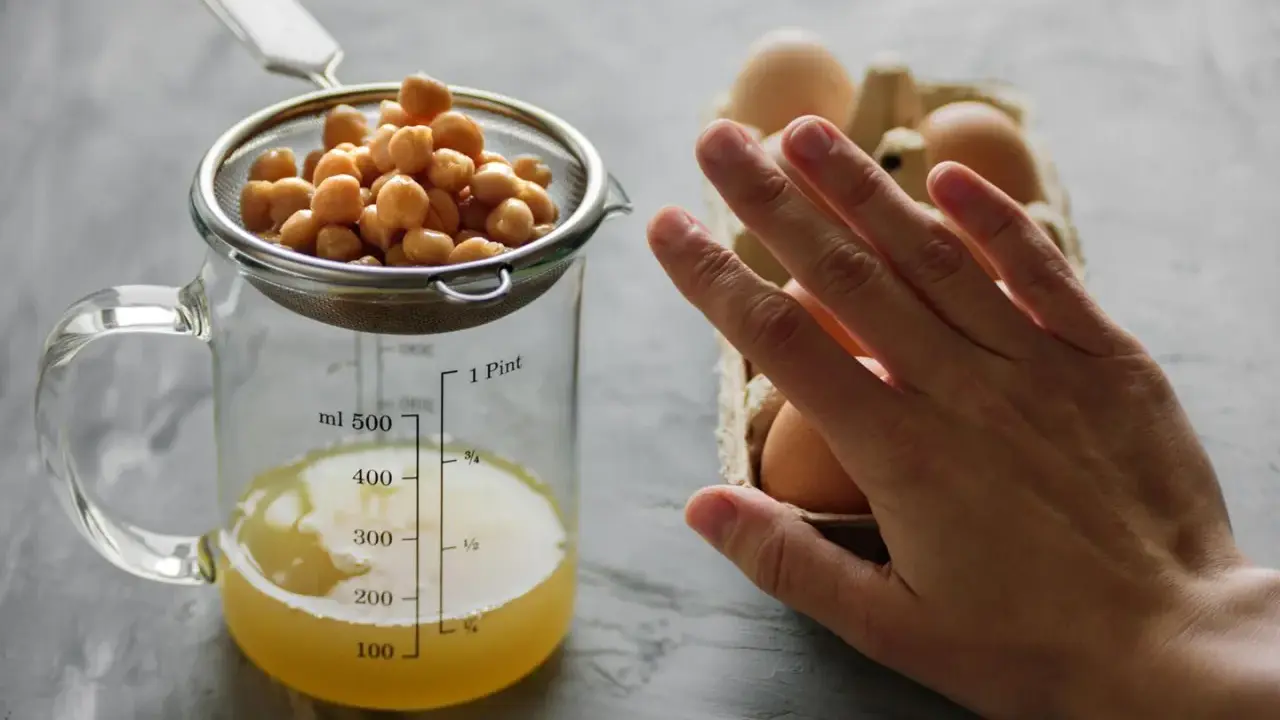 Kichererbsen im Sieb über Messbecher mit Aquafaba. Eier im Hintergrund. Perfekt für ei ersatz backen.
