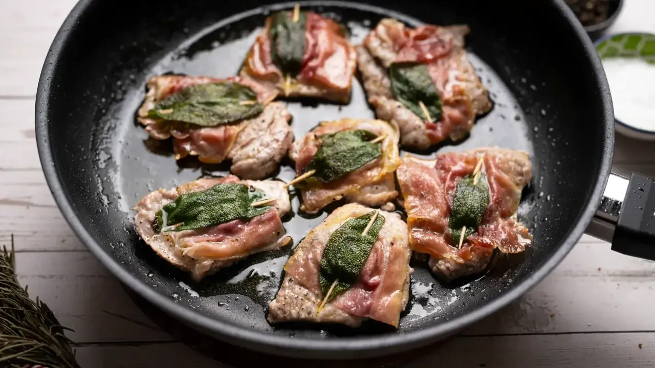 Saltimbocca alla romana in einer Pfanne, mit Salbei und Parmaschinken umwickelt.