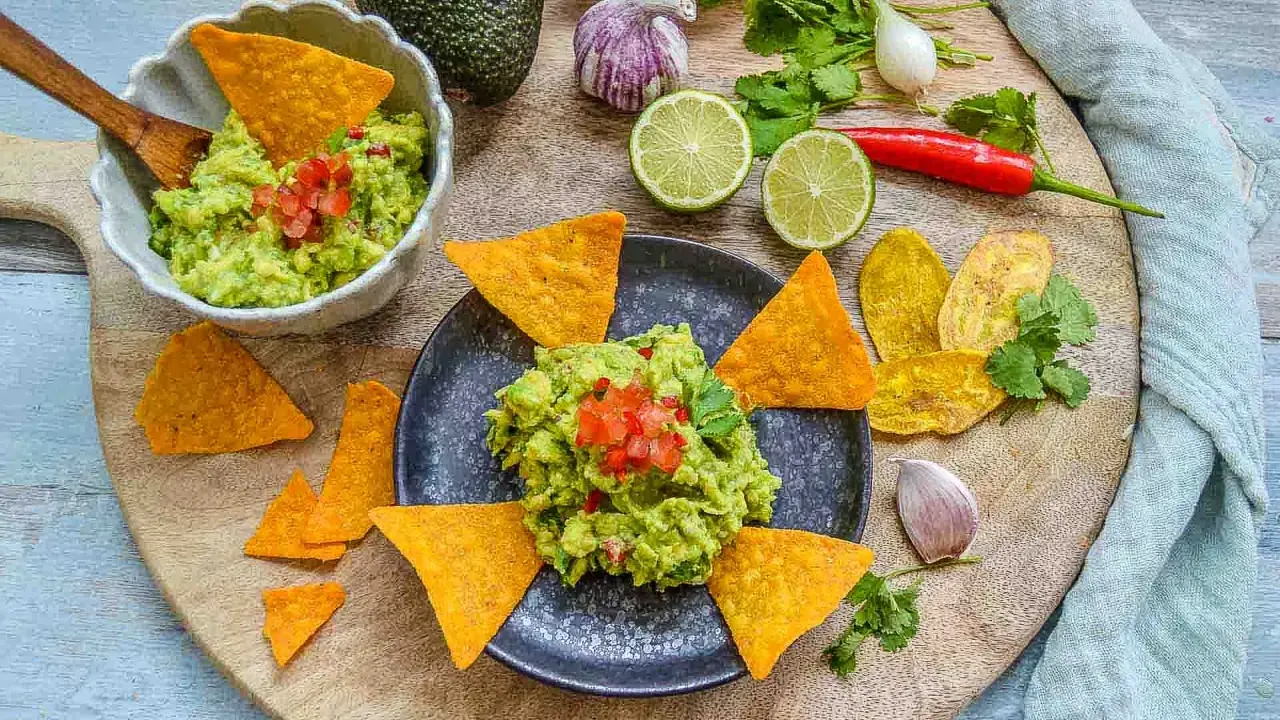 Frisches Guacamole-Rezept mit Avocados, Limetten, Chili und Koriander, serviert mit Tortilla-Chips.