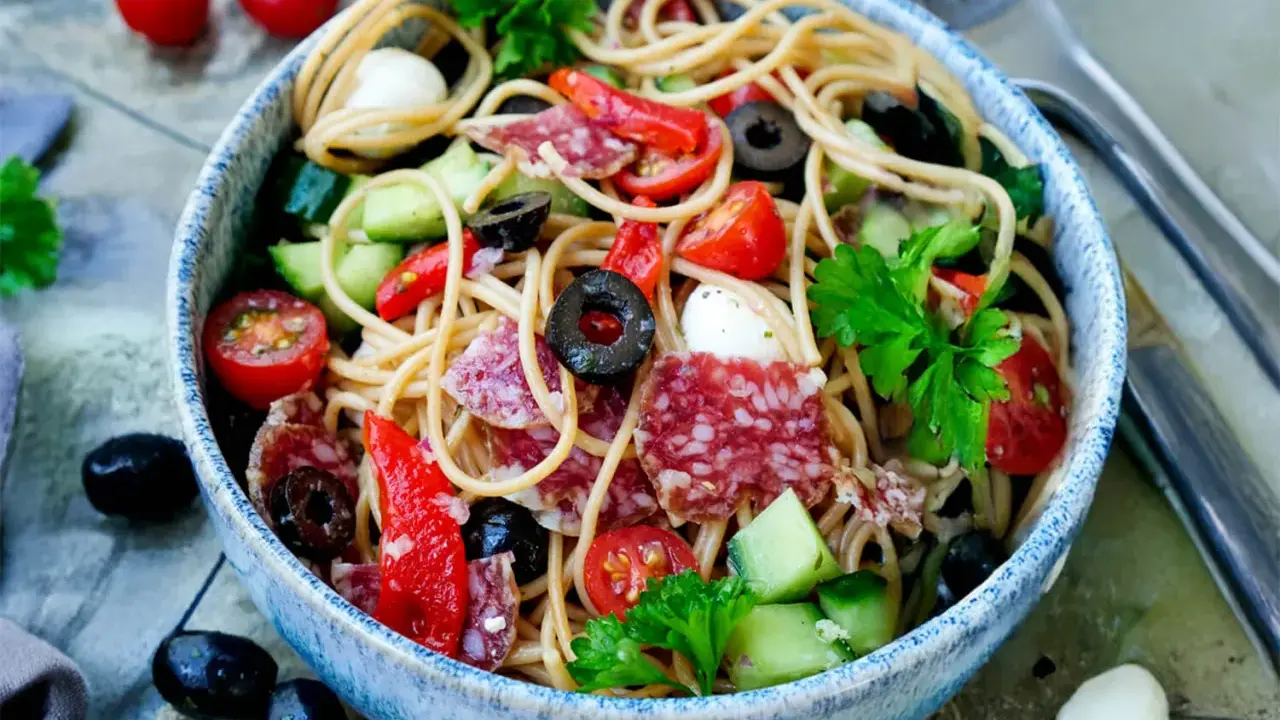 Ein bunter Spaghetti Salat mit Salami, Tomaten, Oliven und Mozzarella. Perfekt für einen spaghetti salat einfach und schnell.