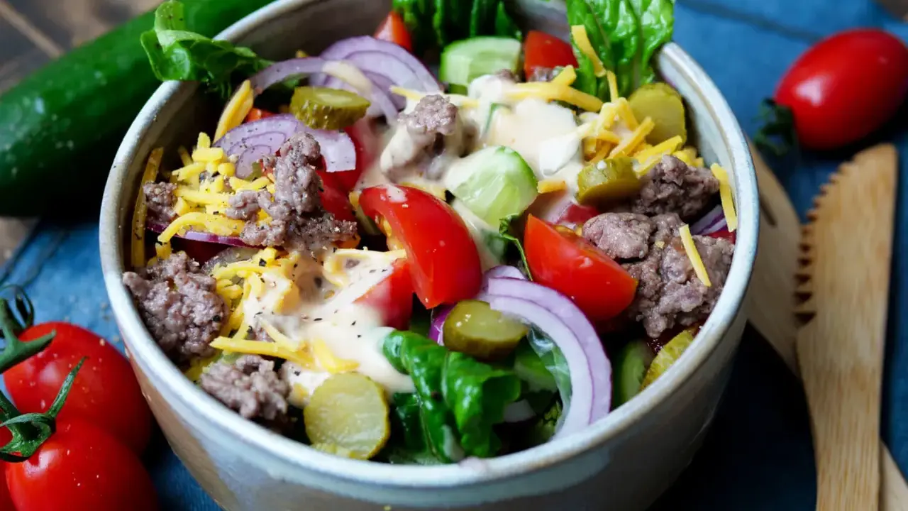 Ein bunter Big Mac Salat mit Hackfleisch, Käse, Gurken, Tomaten und Zwiebeln, übergossen mit einer cremigen Sauce.