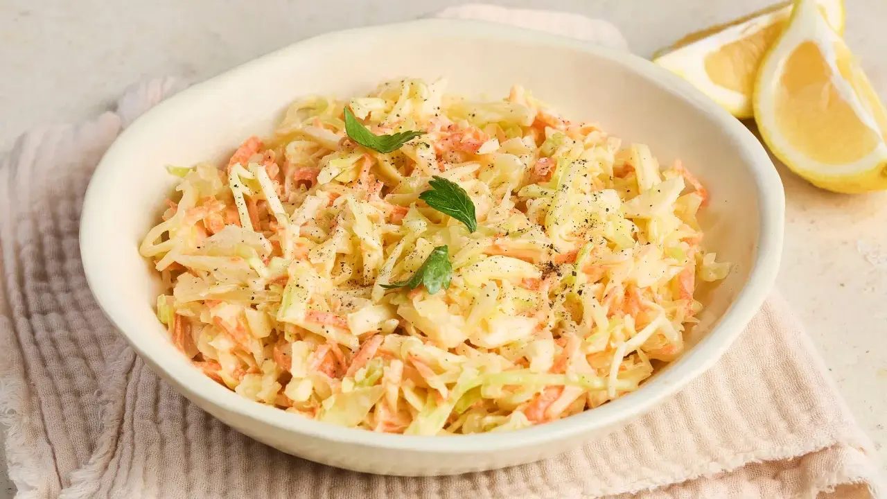 Cremiger Krautsalat, perfekt für jedes coleslaw rezept. Mit frischer Petersilie und Zitronenspalten garniert.