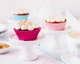 Rhabarber Muffins mit Baiser: Süße Leckereien in bunten Förmchen, bereit für den Genuss mit einer Tasse Kaffee.