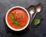Schüssel mit frischer Tomatensauce, garniert mit Basilikum und Pfeffer. Perfekt, um Tomatensauce selber machen zu lernen.