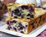 Saftiger Heidelbeerkuchen mit Streuseln, ein Stück gestapelt auf dem ganzen Kuchen.