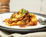 Herzhaftes italienisches Gericht: breite Bandnudeln mit einer reichhaltigen Rindfleischsauce, garniert mit frischen Kräutern.