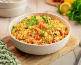 Frischer Couscous Salat mit Tomaten, Gurken und Paprika, garniert mit Petersilie. Ein leichter und gesunder Genuss.