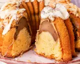 Ein saftiger Gugelhupf mit Birnenfüllung, dekoriert mit weißer Schokolade und Mandeln. Ein Klassiker unter den beliebte Kuchen rezepte.
