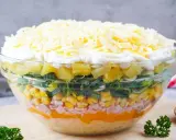 Schichtsalat-Rezept: Bunter Salat mit Ananas, Mais, Schinken, Lauch und Käse in einer Glasschüssel.