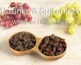 Rosinen & Sultaninen: Wo ist der Unterschied? Zwei Holzschalen gefüllt mit dunklen Rosinen und Sultaninen, im Hintergrund frische rote und grüne Trauben.