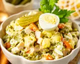 Ein köstlicher Olivier Salat, garniert mit Ei und Gurke, bereit zum Genießen.