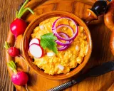 Leckeres Obazda Rezept mit Radieschen und Zwiebelringen garniert, bereit zum Genießen.
