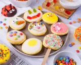 Bunte Kekse mit Zuckerguss, inspiriert von einem amerikanischen Rezept: Marienkäfer, Küken, Karotten und Gesichter.