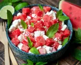 Erfrischender Wassermelonensalat mit Feta und Minze, perfekt für ein leichtes sommersalat rezept. Dazu passen Limettenspalten und Holzbesteck.