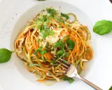 Bunte Spaghetti mit cremiger Gorgonzola-Sauce und frischem Basilikum, garniert mit Pfeffer. Ein Genuss für Augen und Gaumen.