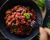 Ein köstlicher rote Linsen Salat mit Roter Bete und frischer Petersilie, serviert in einer dunklen Schüssel.