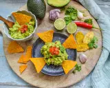 Frisches Guacamole-Rezept mit Avocados, Limetten, Chili und Koriander, serviert mit Tortilla-Chips.