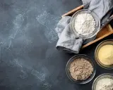 Schalen mit verschiedenen Mehlsorten, darunter auch was ist glutenfreies Mehl, auf dunklem Untergrund.