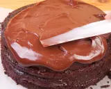 Schokoladenkuchen wird mit glatter, glänzender Ganache überzogen. Was ist eine Ganache? Eine köstliche Mischung aus Schokolade und Sahne.