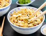 Ein Schüsselchen "friss dich dumm Salat" mit Nudeln, Gemüse und Erdnüssen, bereit zum Genießen mit Stäbchen.