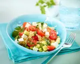 Erfrischender Couscous Salat mit Feta, Tomaten und Gurke in einer blauen Schüssel, bereit zum Genießen.