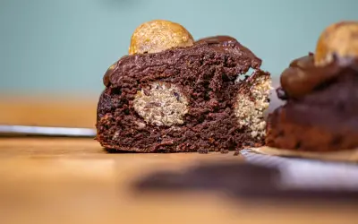 Saftiger Schokoladenkuchen mit versteckten Cookie Dough Kugeln und einem Topping aus Schokoladenglasur und einer weiteren Cookie Dough Kugel.