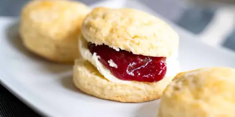 Frisch gebackene Scones mit Clotted Cream und Erdbeermarmelade. Ein perfektes Scones Rezept für den Nachmittagstee.