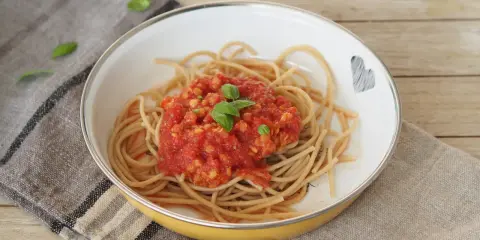 Herzhafte Linsen Bolognese auf Vollkornspaghetti, garniert mit frischem Basilikum. Ein Gericht, das Liebe und Geschmack vereint.