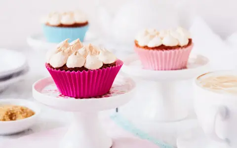 Rhabarber Muffins mit Baiser: Süße Leckereien in bunten Förmchen, bereit für den Genuss mit einer Tasse Kaffee.