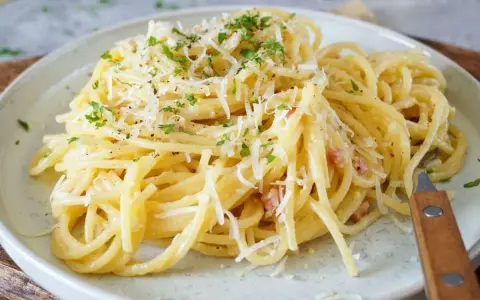 Spaghetti Carbonara, cremig und mit viel Parmesan bestreut. Ob mit nur Eigelb oder ganzem Ei, diese Carbonara ist ein Genuss.