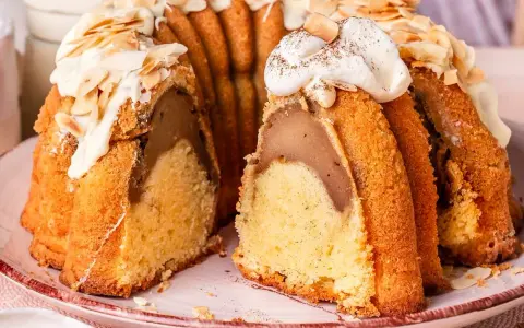Ein saftiger Gugelhupf mit Birnenfüllung, dekoriert mit weißer Schokolade und Mandeln. Ein Klassiker unter den beliebte Kuchen rezepte.