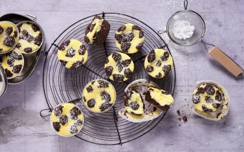 Zupfkuchen Muffins mit Puderzucker bestäubt, auf einem Gitter und in einer Dose.