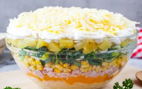 Schichtsalat-Rezept: Bunter Salat mit Ananas, Mais, Schinken, Lauch und Käse in einer Glasschüssel.