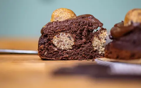 Saftiger Schokoladenkuchen mit versteckten Cookie Dough Kugeln und einem Topping aus Schokoladenglasur und einer weiteren Cookie Dough Kugel.