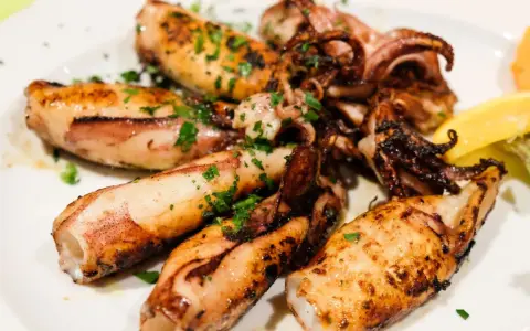 Gegrillte Tintenfischtuben mit Kräutern und Zitrone. Perfekt für ein schnelles Abendessen, aber wie lange im Ofen?